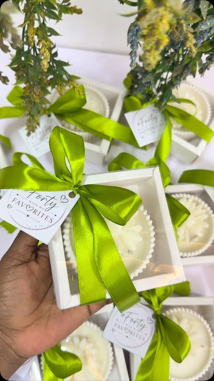 White gift boxes with lime green ribbons and cupcakes for a 40th birthday.