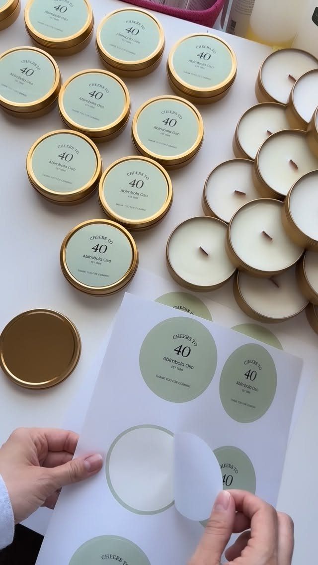 Gold-lidded candles with light green labels celebrating a 40th birthday on white surface.