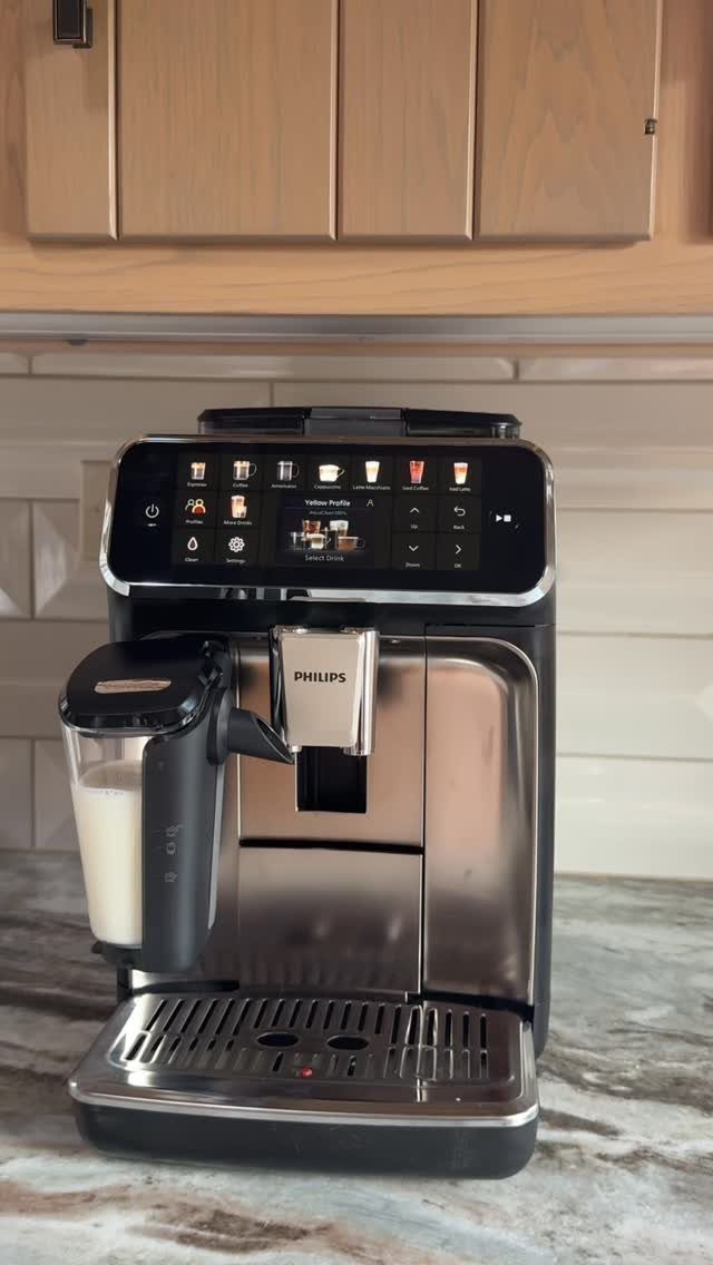 Philips espresso machine with digital screen and milk frother on marble kitchen counter