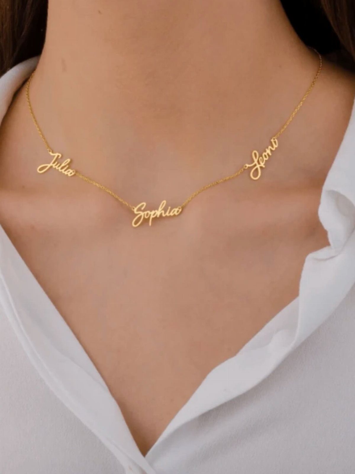 Gold name necklace with Julia, Sophia, and Leoni worn on a white shirt.