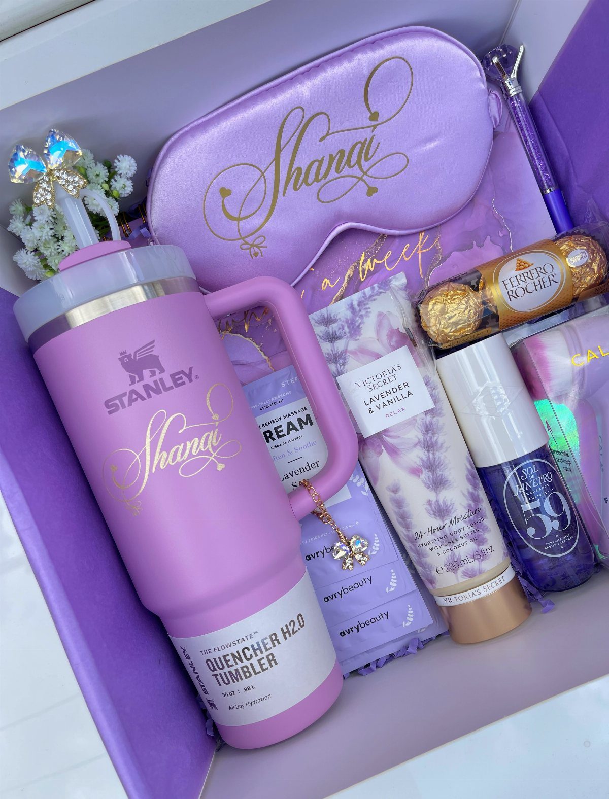 Purple gift box with personalized Stanley tumbler, sleep mask, and beauty products.