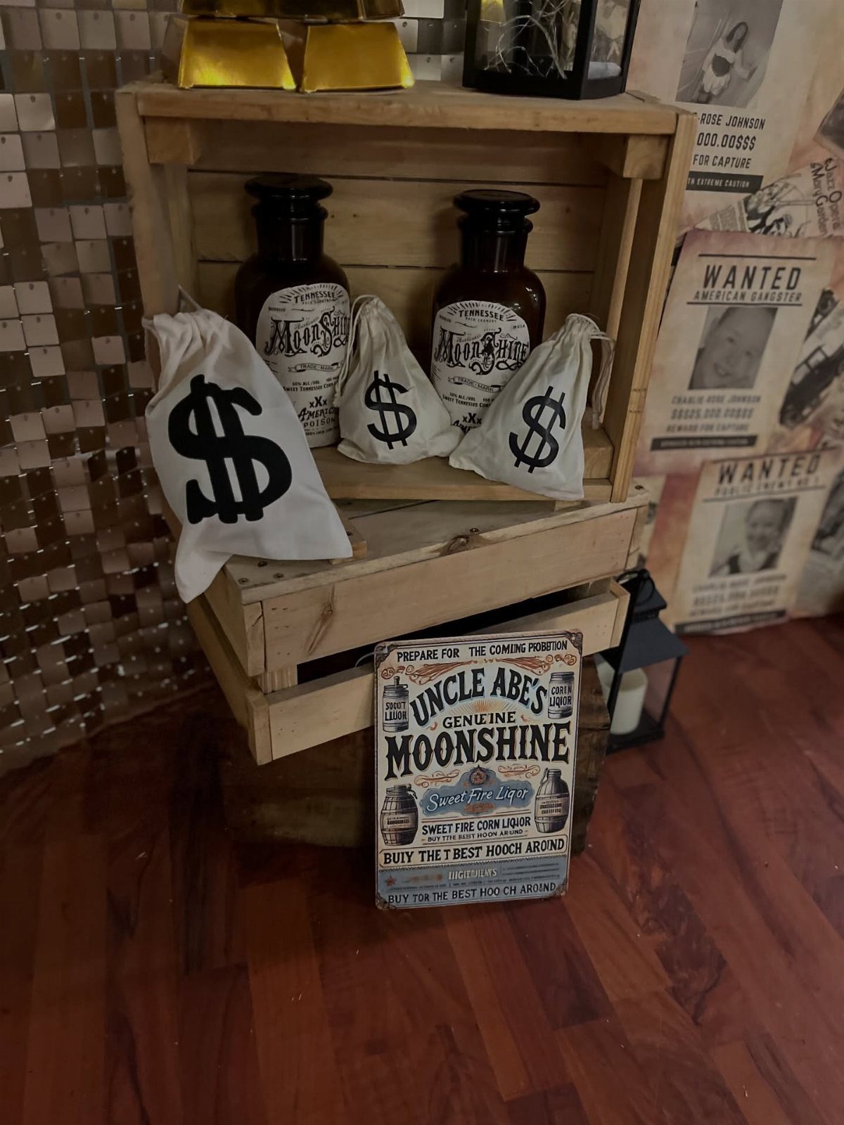 Prohibition-themed party setup with moonshine bottles, money bags, and vintage signage in crates.