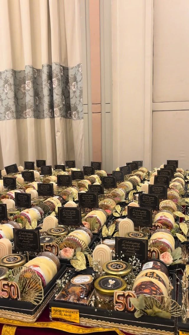 Decorated gift boxes with gold 50 numbers arranged on a table for a birthday.