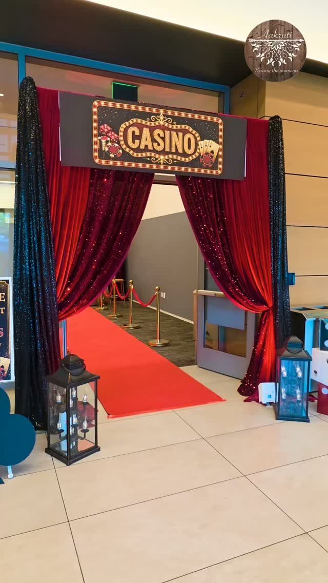 Casino themed party entrance with red carpet, sequined curtains, and a casino sign.