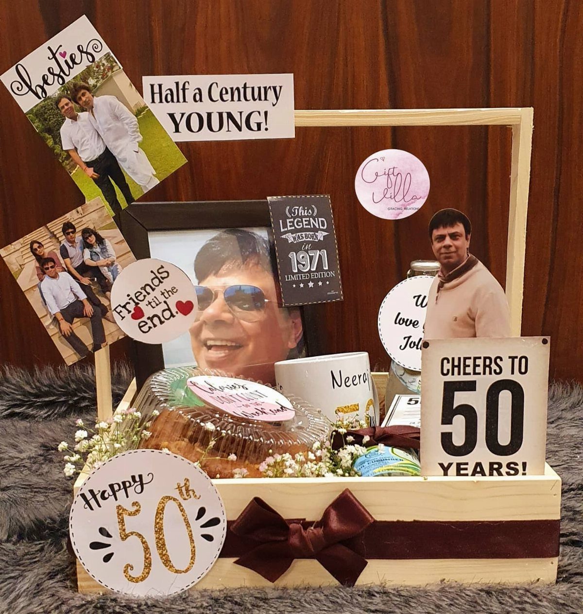 Wooden gift hamper for a 50th birthday featuring photos, a cake, and celebratory cards.