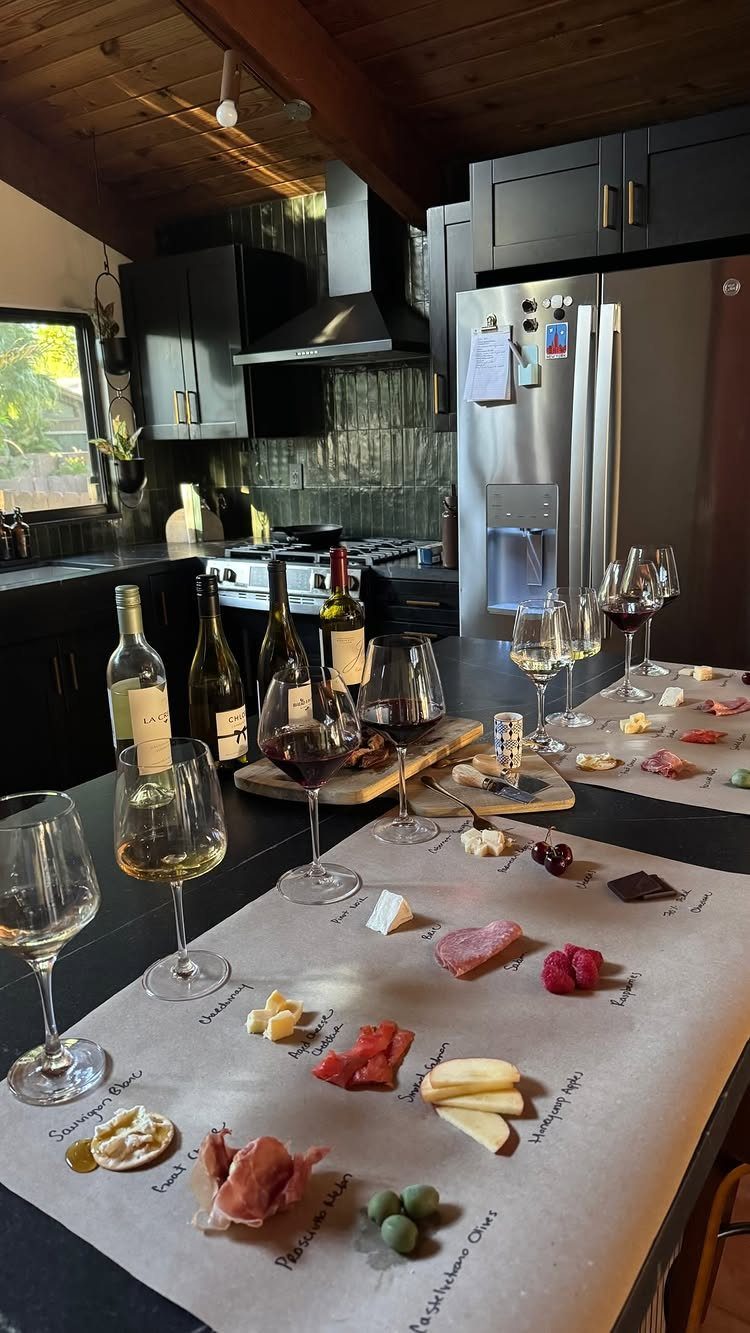 Charcuterie board with various meats and cheeses paired with red and white wine.