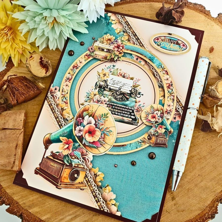 Vintage birthday card featuring a typewriter and gramophone with floral decorations on wood