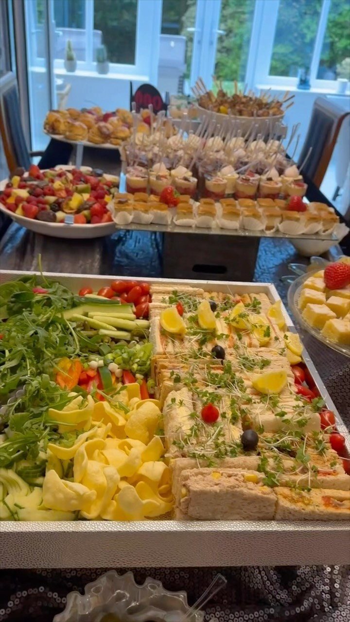 Assorted finger sandwiches and fresh vegetable platters arranged for an afternoon tea party.