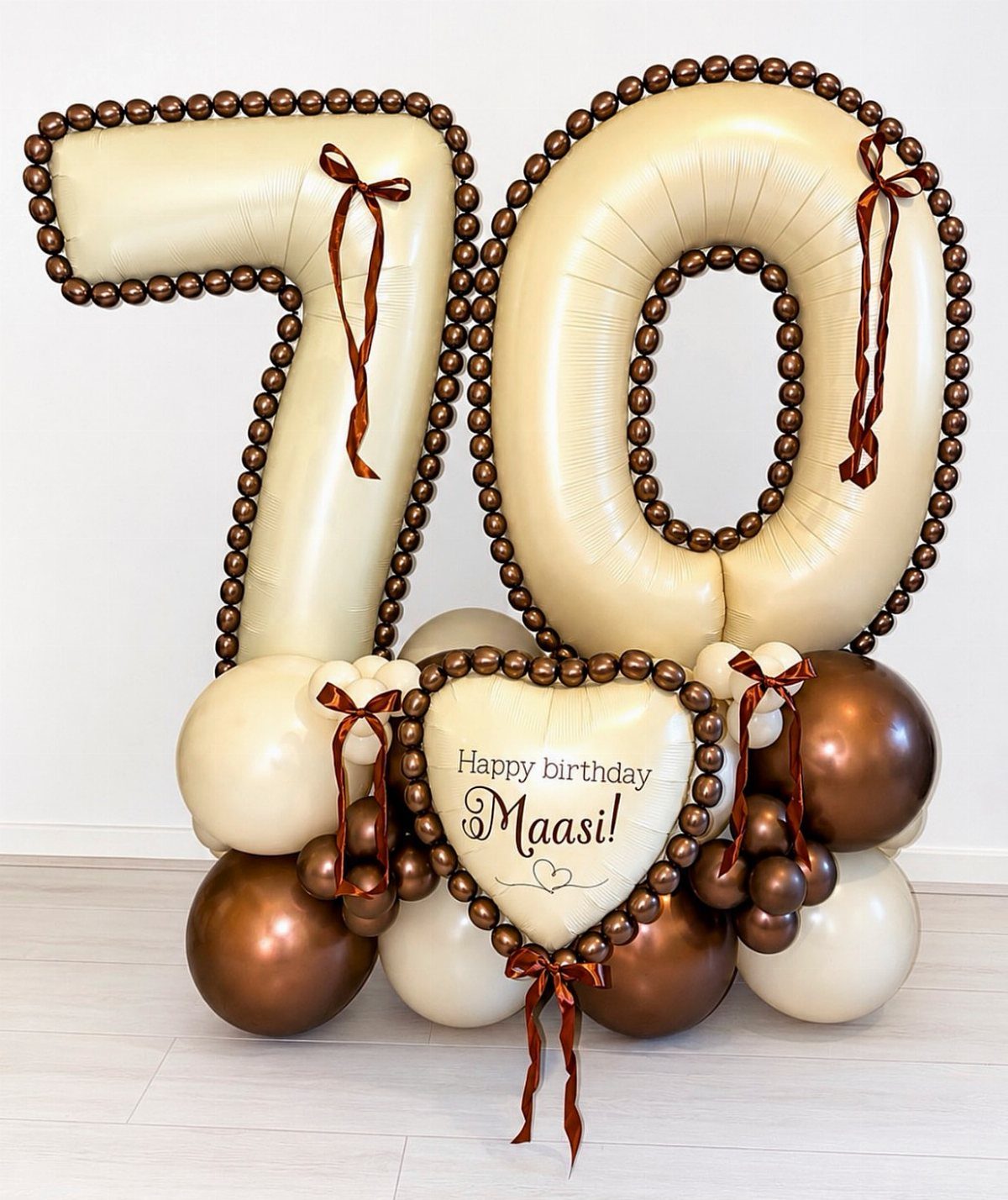 Large cream number 70 balloons with brown accents and a heart birthday balloon.