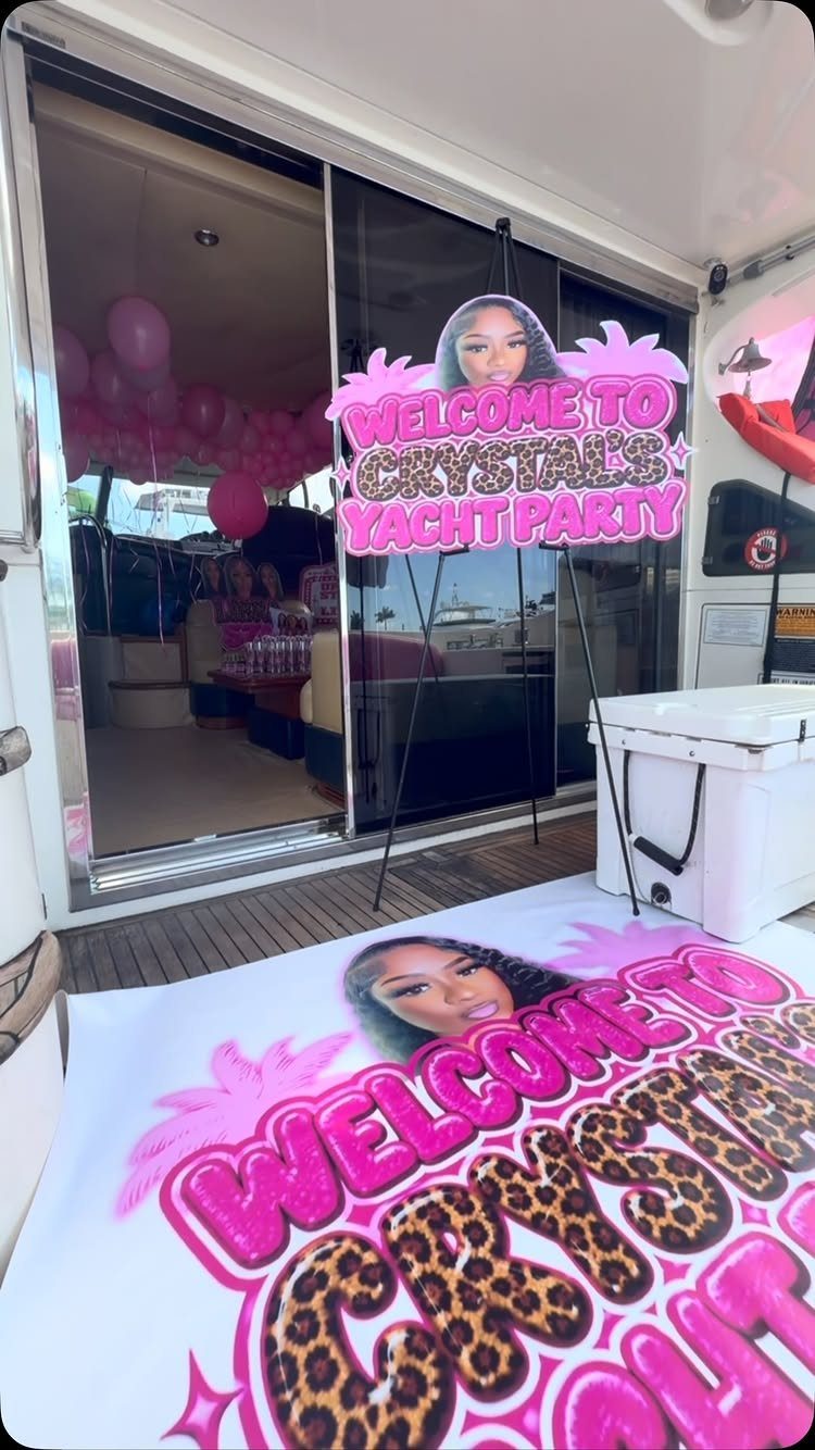 Yacht deck with a pink welcome sign and floor mat for a party.