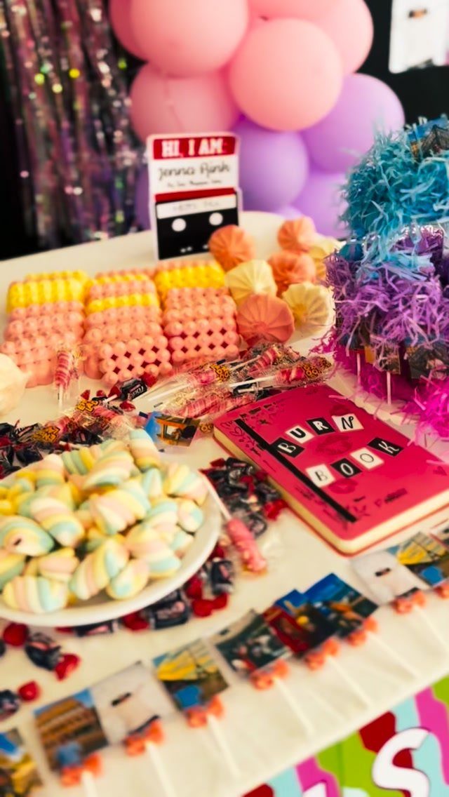Candy buffet with a pink Burn Book and balloons for a movie theme party