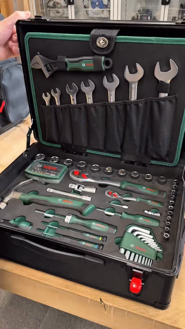Tool set in a black carrying case with green and silver hand tools.