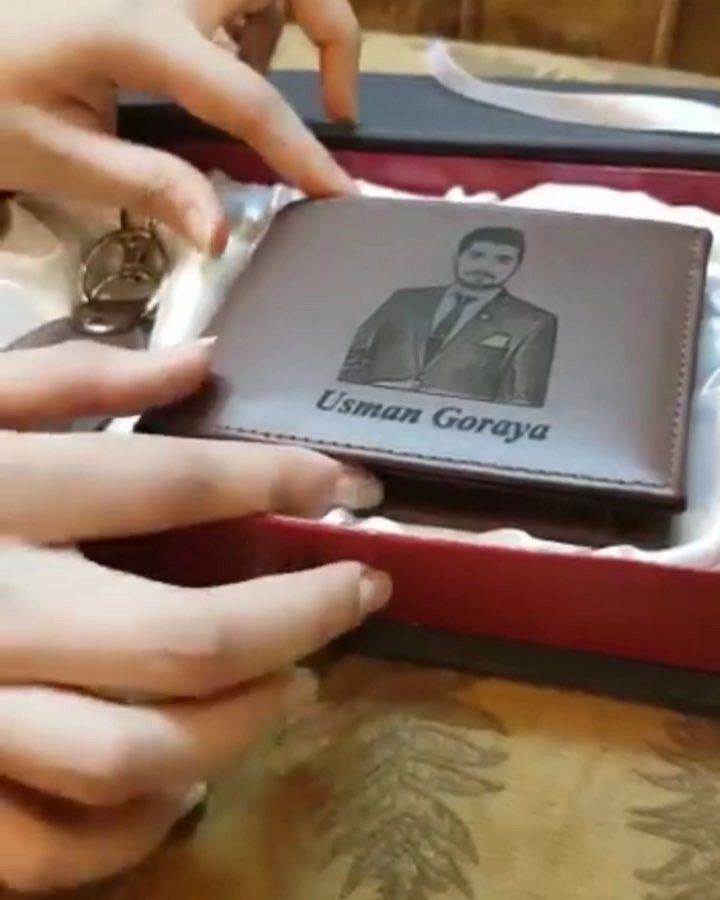 Brown leather wallet with engraved portrait and name inside a gift box