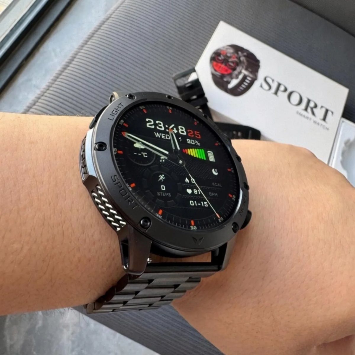 Black smartwatch on a wrist showing fitness data with its packaging in background
