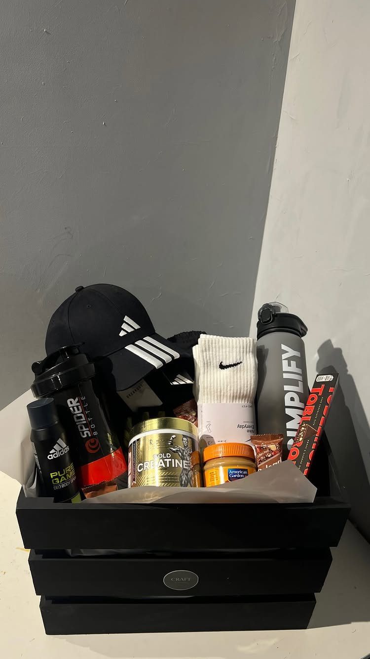 Fitness gift basket with Adidas cap, Nike socks, and supplements in black tray