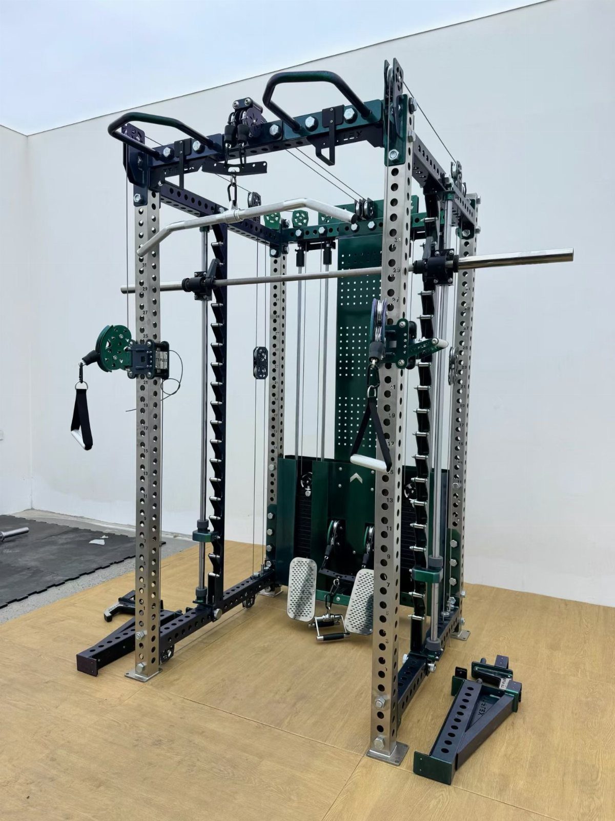Professional green and silver multi-functional gym power rack on a wooden floor