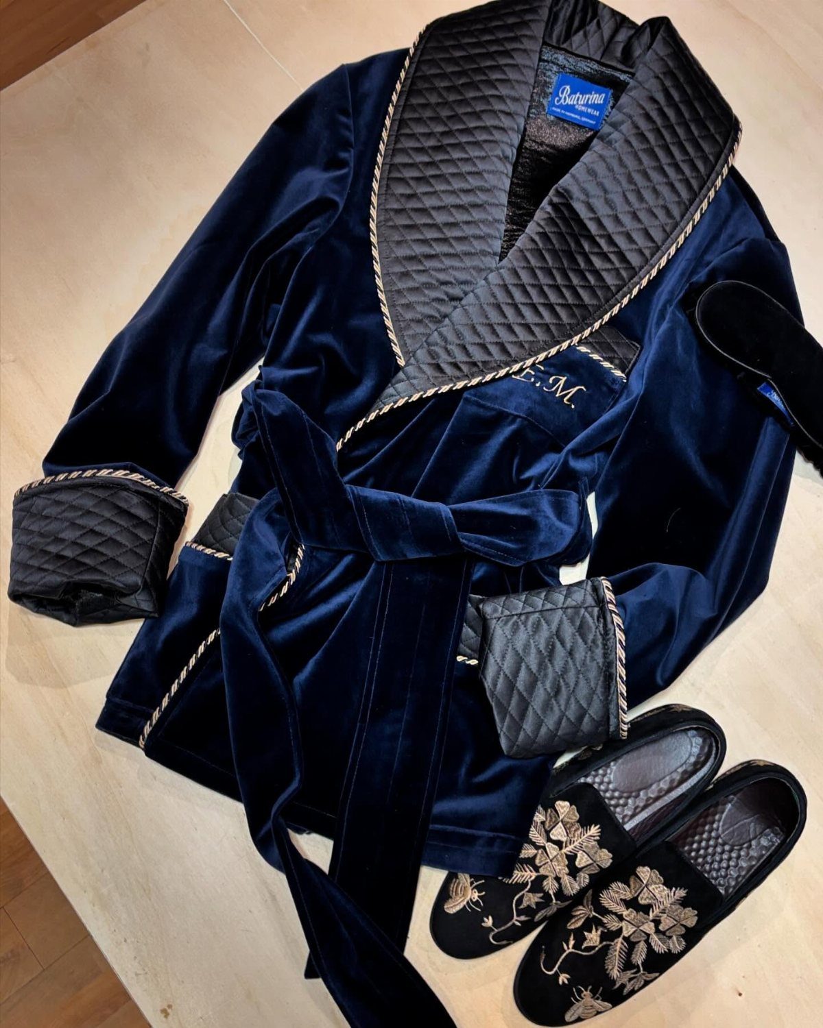 Navy blue velvet smoking jacket with gold trim and matching embroidered velvet slippers.