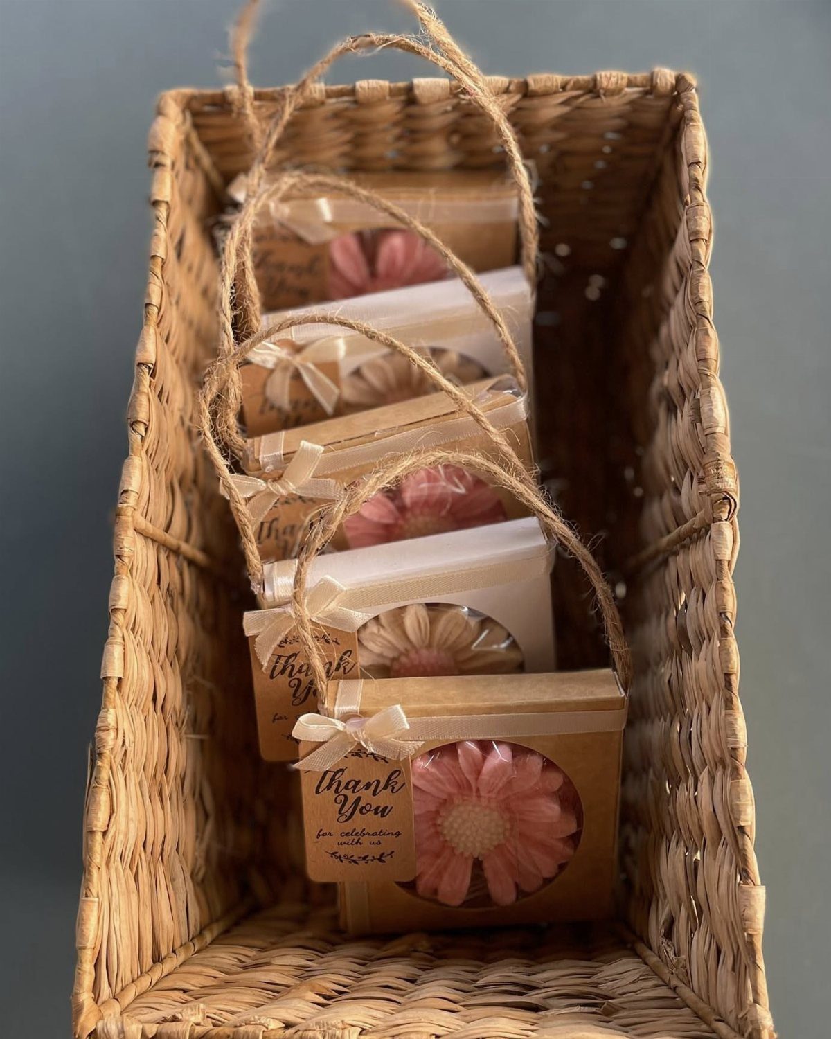 Small kraft paper gift boxes with flowers and thank you tags in a basket