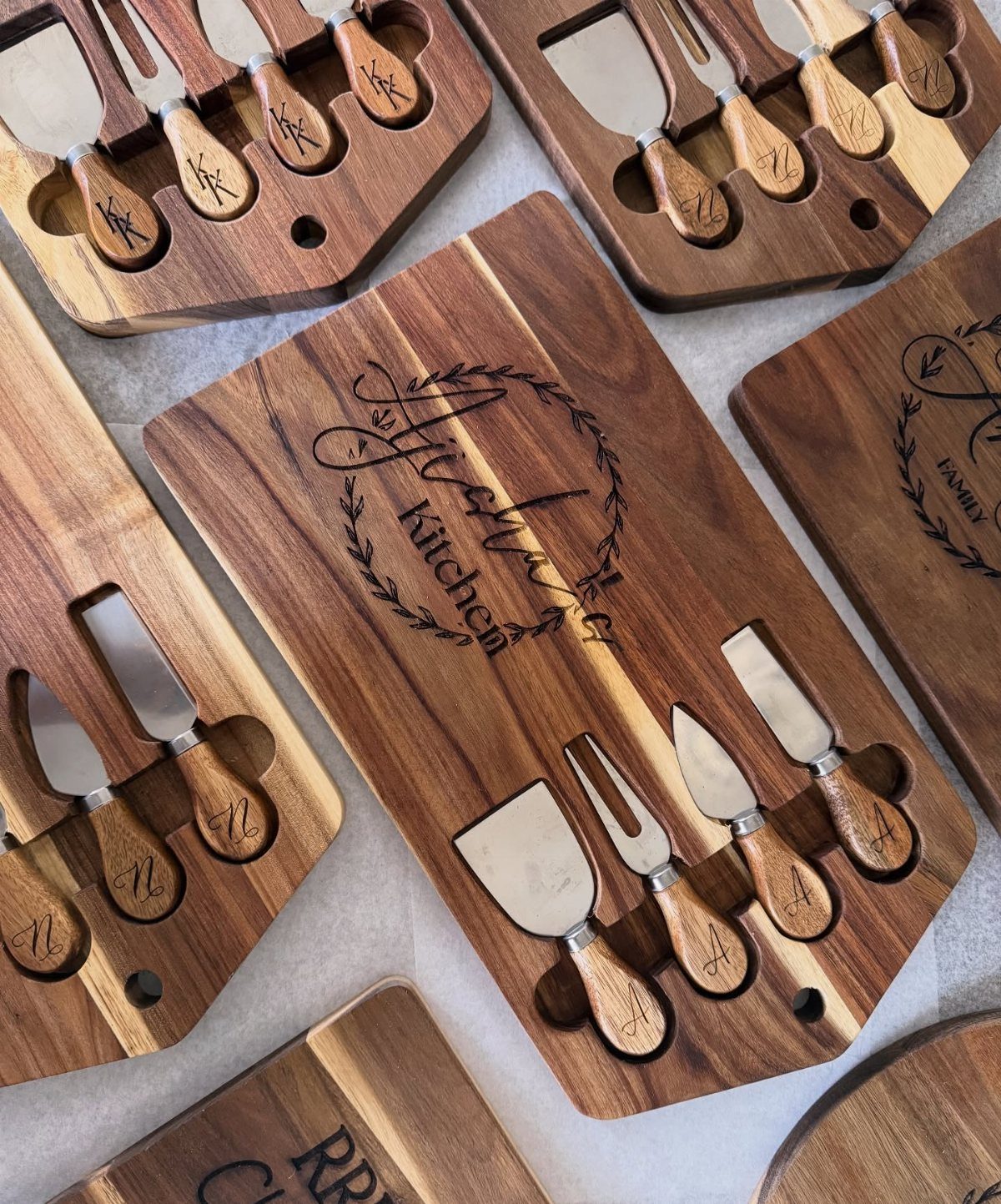 Engraved wooden chopping blocks with matching cheese knife sets in built-in slots.