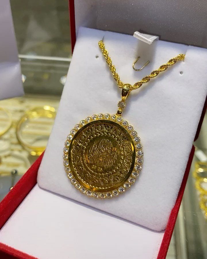 Gold coin pendant necklace with sparkling stones in a red jewelry box