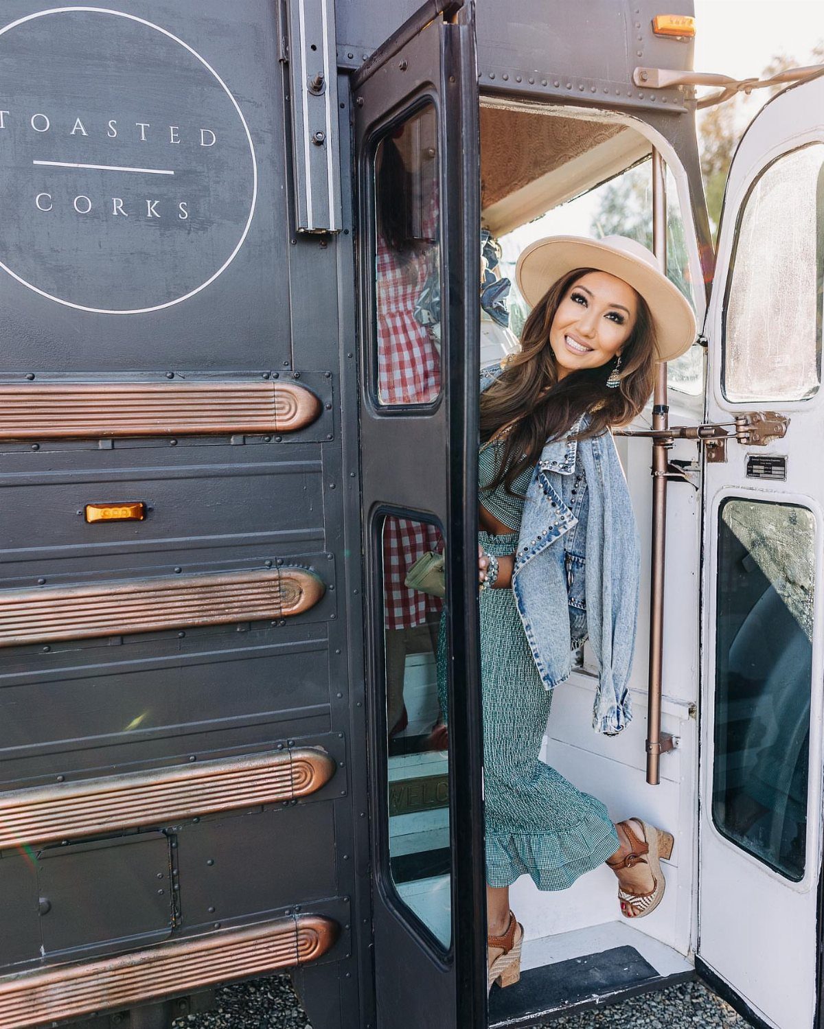 Woman in a sun hat posing in the doorway of a wine tour bus