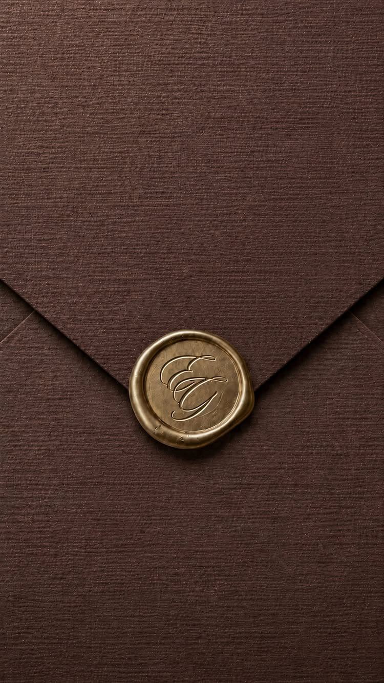 Brown textured envelope sealed with a gold wax stamp featuring a cursive letter.