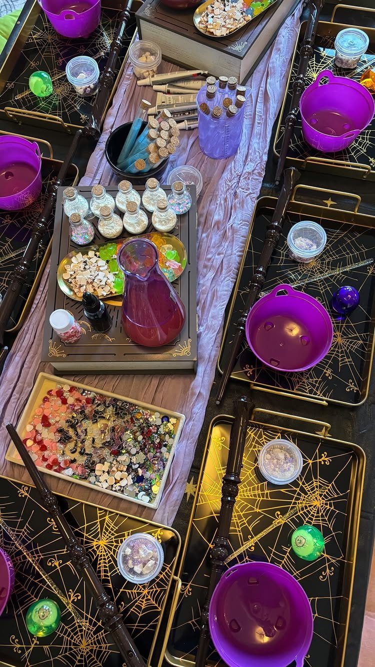Potion making station with purple bowls, glass vials, and colorful crystals on black trays.