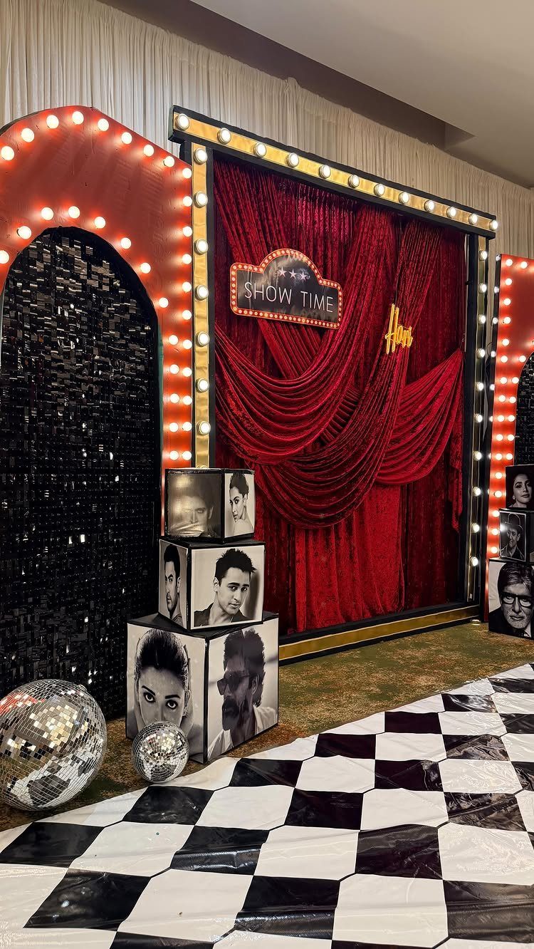 Theatrical party backdrop with red curtains, disco balls, and black and white portraits.