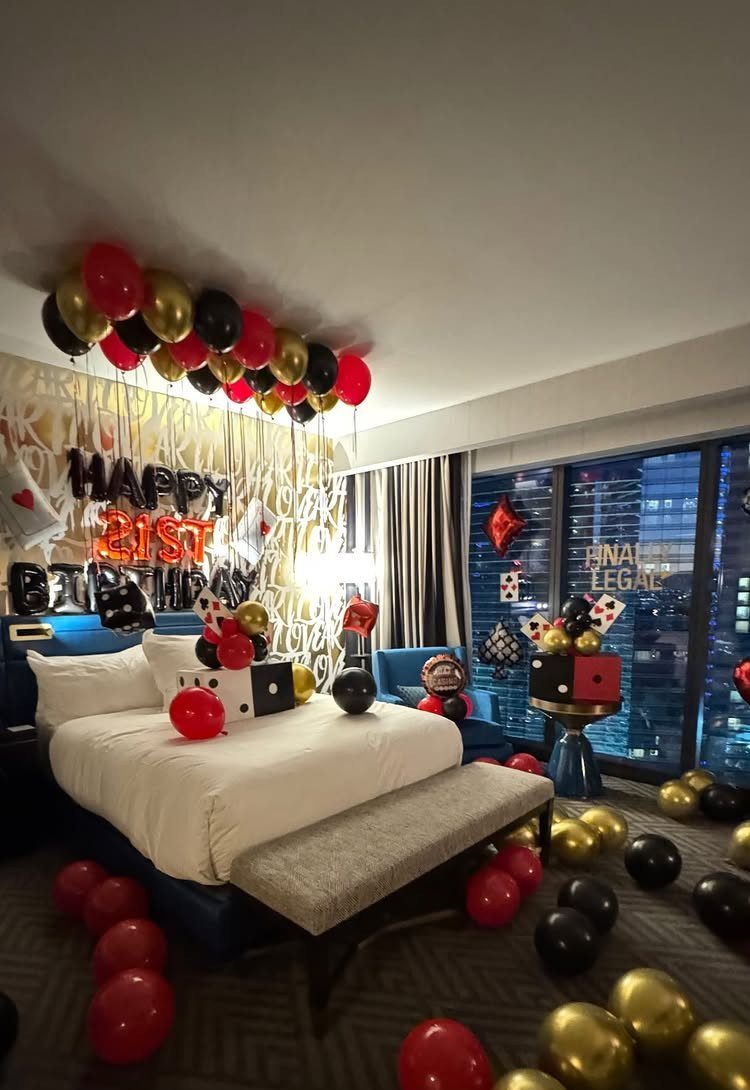 Hotel room decorated with red, black, and gold balloons for a 21st birthday.
