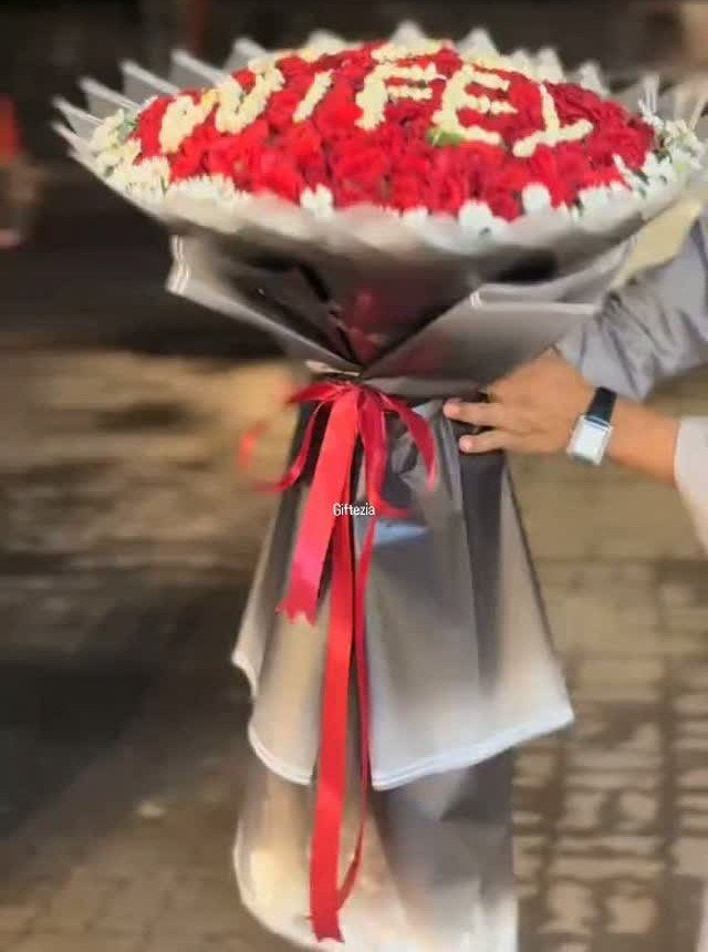 Massive bouquet of red and white roses spelling WIFEY wrapped in silver paper