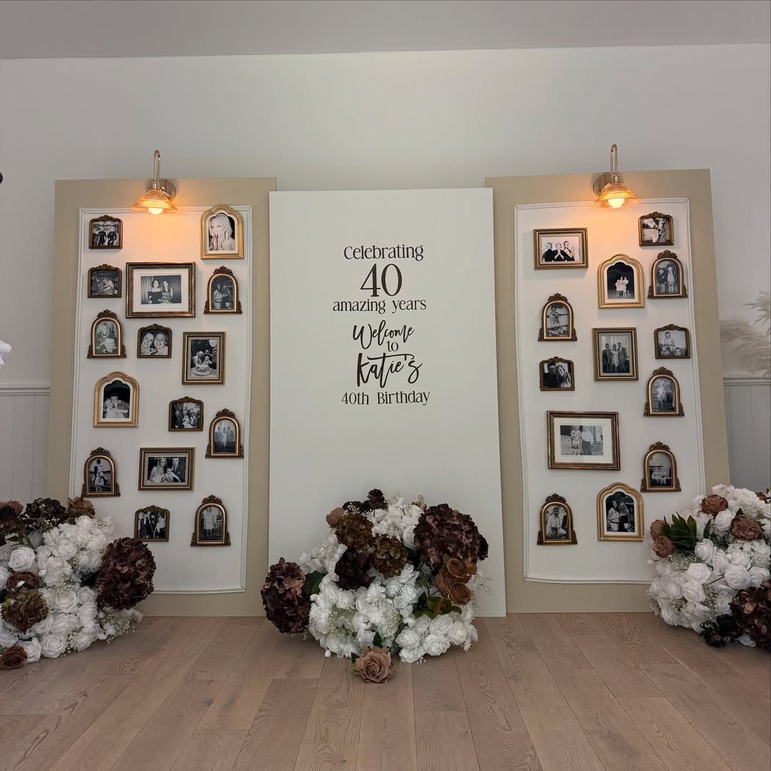 Birthday memory wall with gold-framed photos and floral arrangements for a 40th birthday.