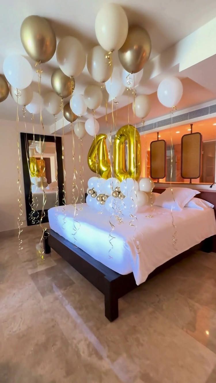 Bedroom decorated with gold and white balloons and gold foil number 40 balloons.