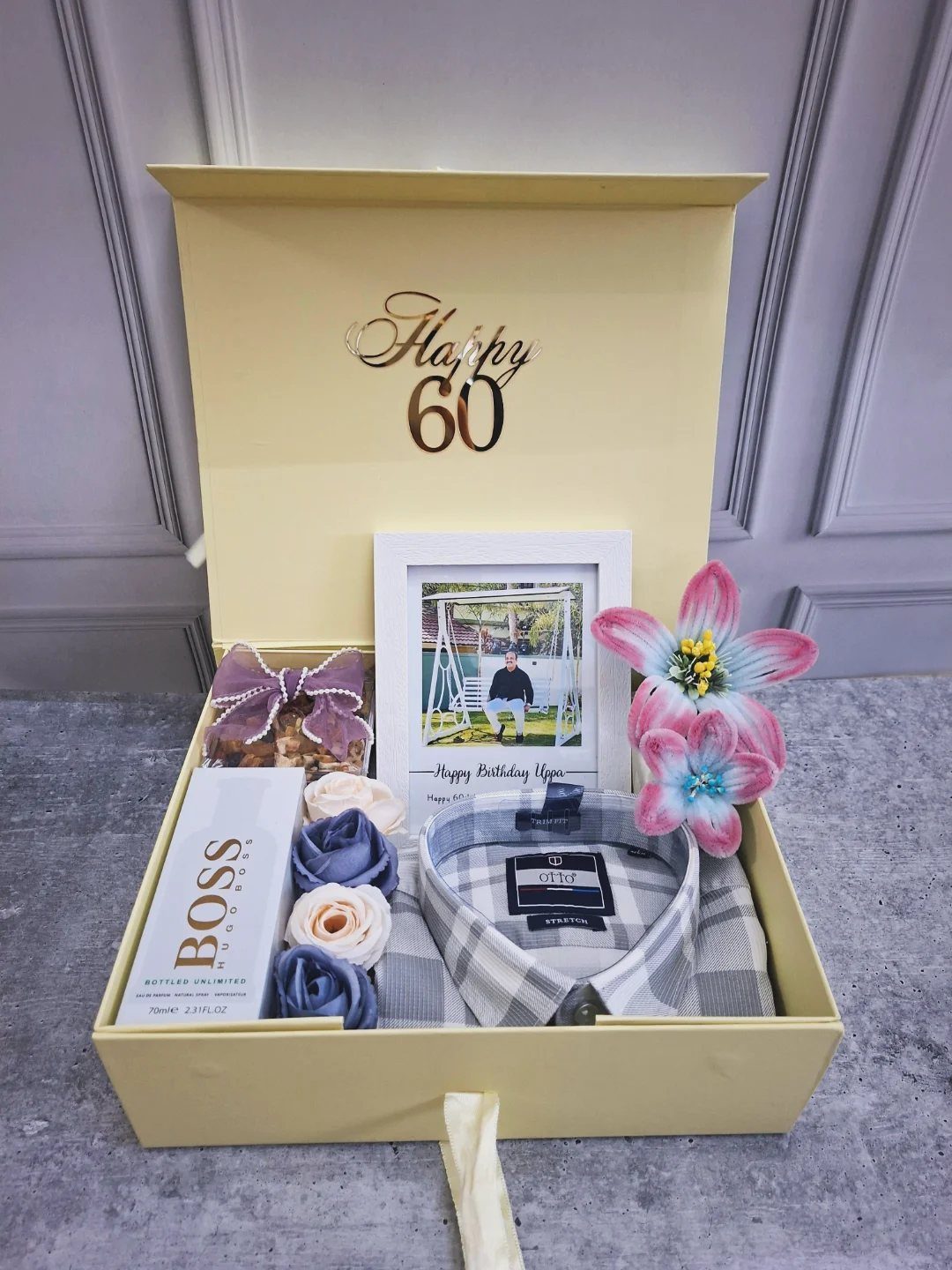 Yellow gift box for 60th birthday containing a shirt, perfume, and framed photo.