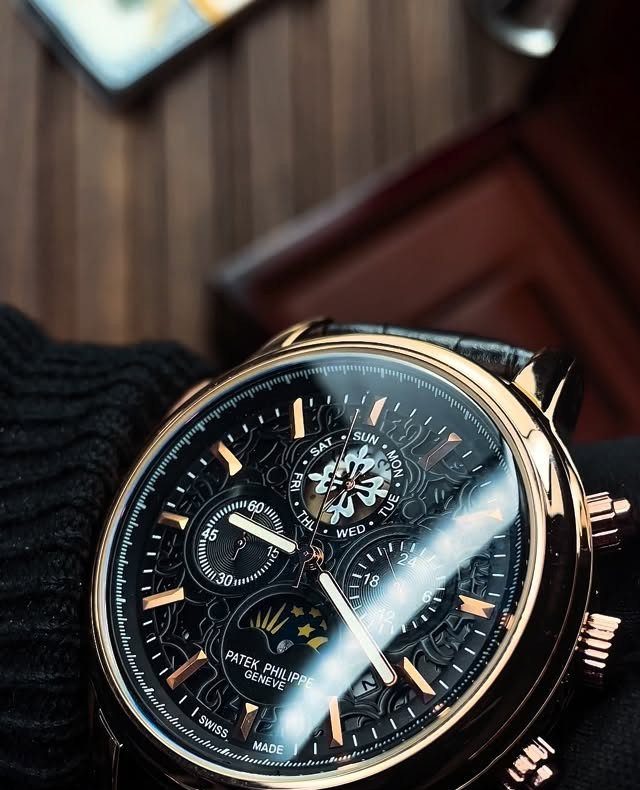 Luxury gold Patek Philippe watch with black dial on a knitted sleeve