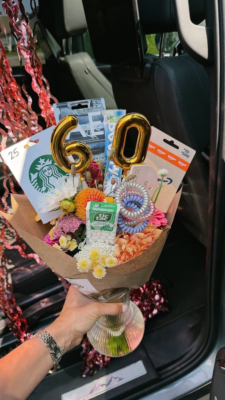 Gift bouquet with flowers, gift cards, and gold 60 balloons for a birthday.